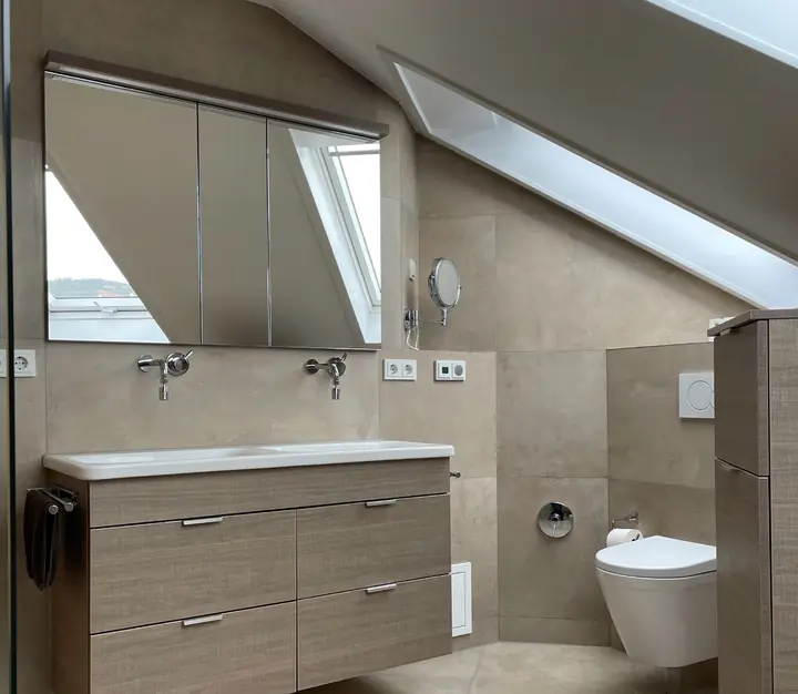 Bad im Dachgeschoss mit großformatigen Fliesen in Steinoptik, Doppelwaschtisch und Wand-WC