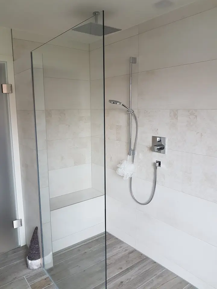 Walk-in-Dusche mit Glaswand und großformatigen Fliesen