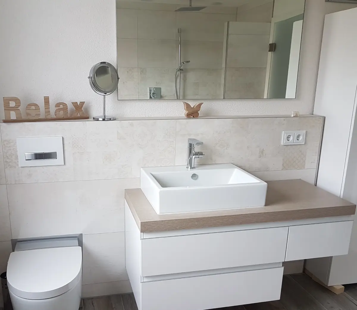 Helles Bad mit gefliester Vormauerung, Aufsatzwaschbecken und Wand-WC