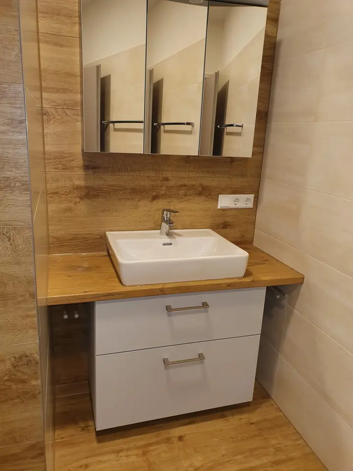 Waschtisch vor Wandfliesen in Holzoptik